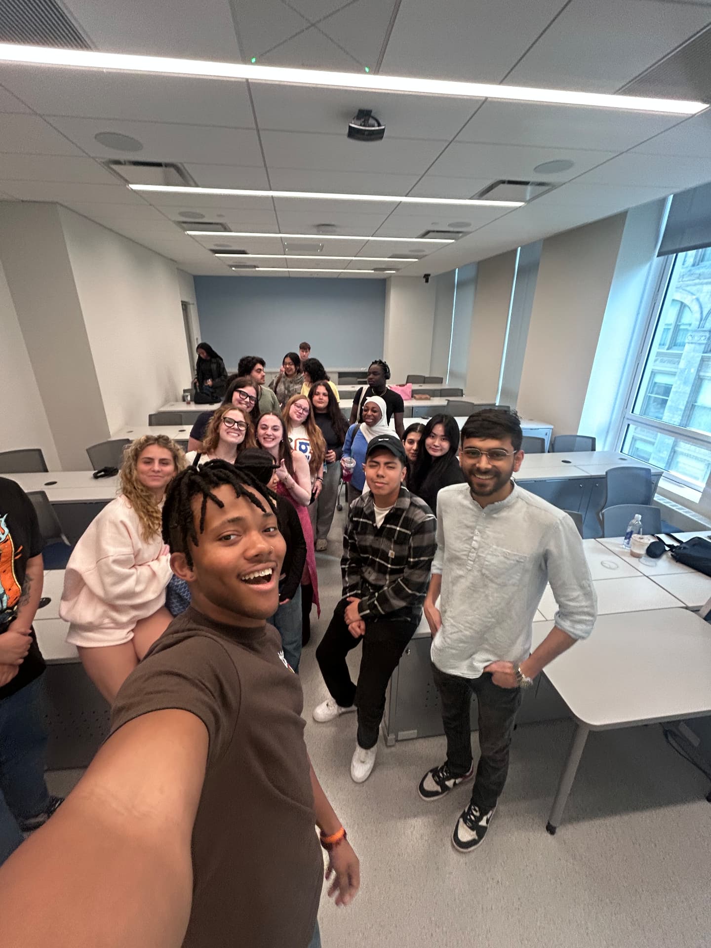 Om Gaikhe taking a selfie with students in a classroom