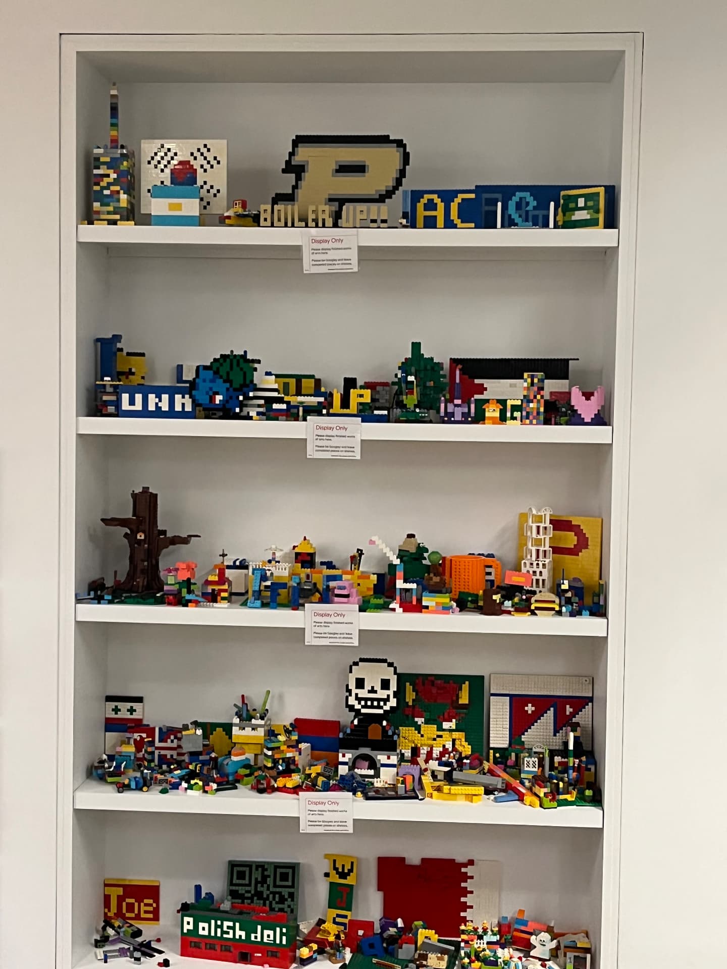 Shelf of LEGO art builds on display